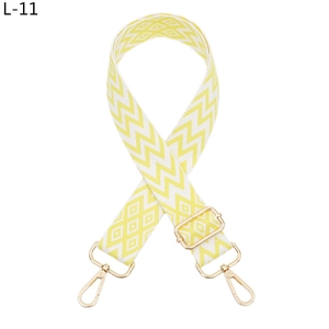 Close-up of yellow and white wave geometric pattern shoulder strap with gold metal buckles