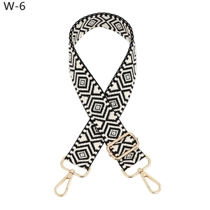Close-up of black and white geometric jacquard strap with golden rotating metal hooks