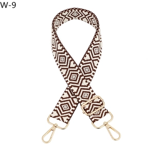 Detail of geometric brown and white woven strap with polished gold metal buckles