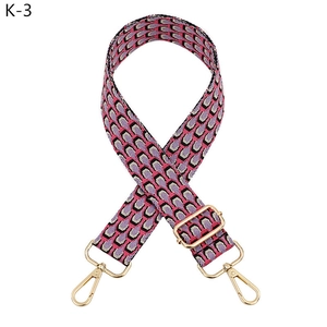 Close-up of pink and purple peacock pattern woven bag strap with golden lobster clasps