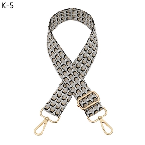 Close-up of geometric jacquard shoulder strap with gold-tone swivel snap hooks