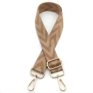 Macro view of adjustable woven shoulder strap with beige and brown herringbone pattern