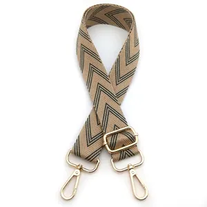 Detail of khaki geometric woven strap with gold metal hooks for handbags