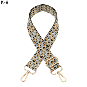 Detail of adjustable peacock pattern bag strap with gold metal swivel lobster clasps