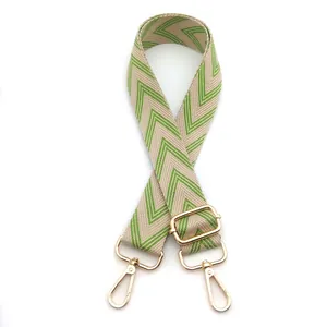 Detail of adjustable green and beige woven canvas guitar strap with gold metal buckles