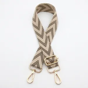 Detail of adjustable black and beige chevron woven strap with light gold metal swivel hooks