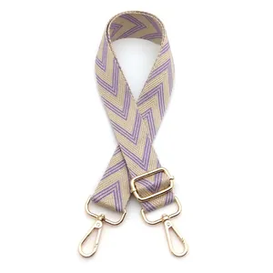 Detail view of purple and beige geometric canvas strap with gold metal lobster clasps