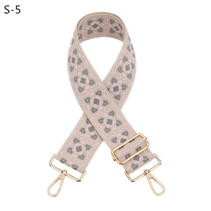Dettaglio della tracolla larga in jacquard con motivi geometrici e ganci in oro lucido