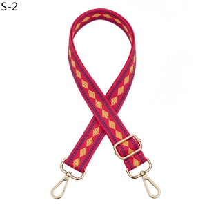 Detail view of woven adjustable bag strap with magenta and yellow geometric patterns