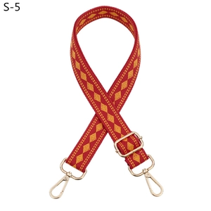 Detail view of ethnic red and yellow geometric woven strap with gold metal buckle