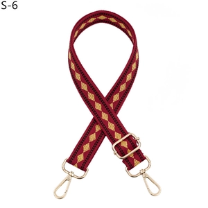 Detail of adjustable woven shoulder strap in burgundy and gold with metal swivel hooks