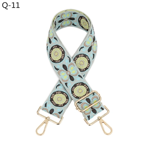 Detail of bohemian jacquard wide bag strap with gold metal buckle and floral embroidery