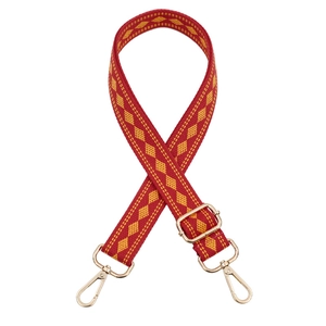 Adjustable woven shoulder strap with red and orange geometric patterns and gold clips