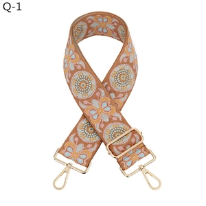 Detail of bohemian wide bag strap with colorful geometric embroidery and gold metal hardware