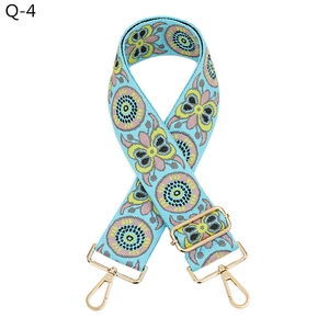Close-up of light blue thickened bag strap with butterfly embroidery and gold metal hooks