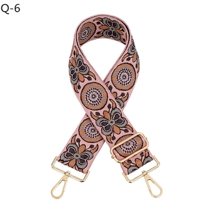 Detail of bohemian pink woven bag strap with retro geometric patterns and gold lobster clasp