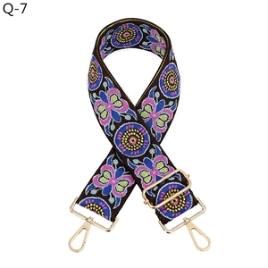 Detail view of ethnic jacquard strap with golden swivel snap hooks and adjuster