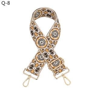 Detailed view of bohemian sunflower pattern wide fabric strap with gold metal hooks