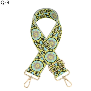 Close-up of retro woven bag strap with yellow geometric patterns and gold metal clips