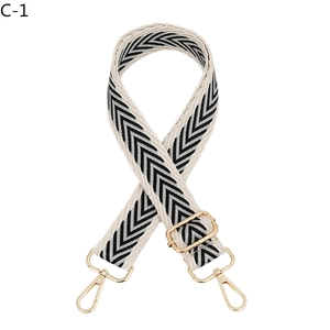 Detail view of woven black and white chevron bag strap with gold metal lobster hooks