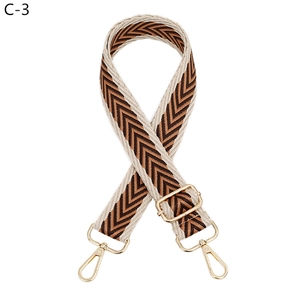 Detail of adjustable chevron strap with golden hardware in brown and beige