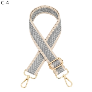 Detail view of thickened adjustable beige and grey wave pattern woven purse strap with gold hooks