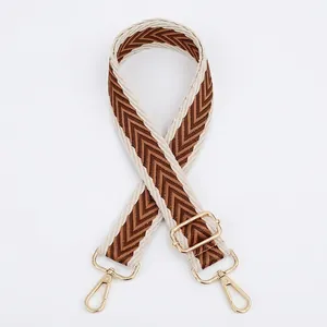 Adjustable wide woven shoulder strap with brown chevron pattern and gold metal hooks