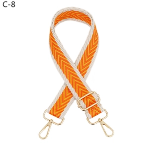 Detail of adjustable orange and white herringbone woven strap with golden metal hooks