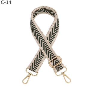 Close-up of thick woven canvas shoulder strap with green chevron pattern and gold metal hardware