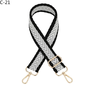 Detail of adjustable bag strap featuring a black and white herringbone weave pattern