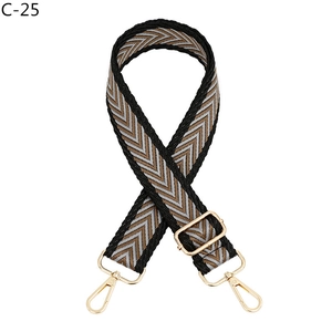 Detail of V-pattern woven bag strap with golden metal buckles and adjustable slider