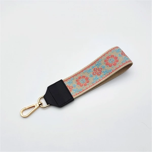Close-up of ethnic style embroidered strap with floral patterns and gold lobster clasp