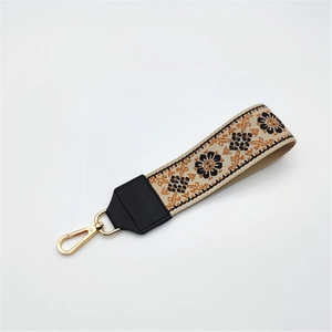 Detail of ethnic style strap with bohemian floral embroidery and gold lobster clasp