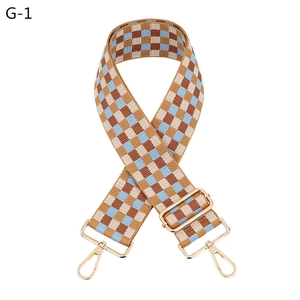 Detail of adjustable plaid bag strap in brown and blue with gold swivel lobster clasps