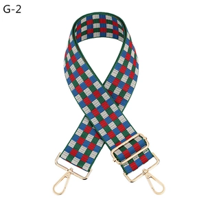 Macro detail of checkered wide shoulder strap with golden hooks and adjustable metal buckle