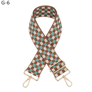 Close-up of checkered adjustable shoulder strap with gold-tone metal lobster clasps