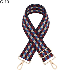 Detail of adjustable plaid bag strap with blue red pattern and gold metal hooks