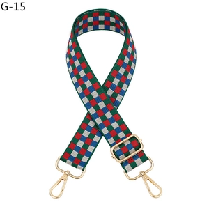 Detail view of colorful checkerboard bag strap with adjustable gold lobster buckles