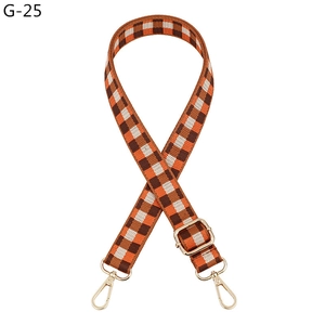 Detail of adjustable checkerboard bag strap with golden swivel hooks and buckles