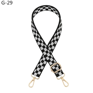 Close-up of adjustable checkerboard bag strap with high-quality gold metal hooks