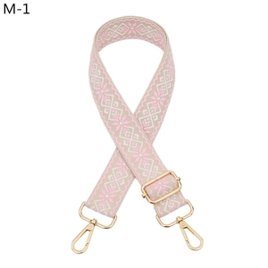 Detail of pink and beige geometric ethnic woven bag strap with golden alloy hooks