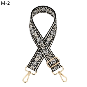 Detailed close-up of ethnic geometric jacquard strap with gold-tone metal hooks