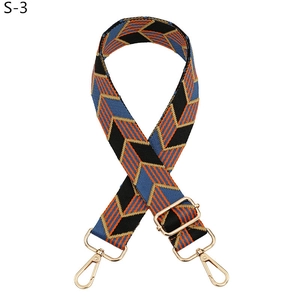 Detail of adjustable bag strap with orange and blue chevron pattern and gold lobster clasps