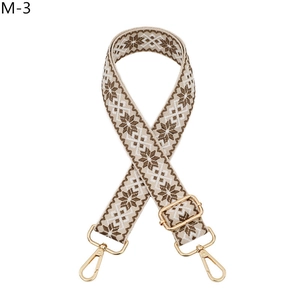 Close-up of ethnic style jacquard guitar strap with gold metal buckles and lobster hooks