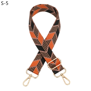 Detail of woven bag strap with orange and black chevron pattern and gold lobster clasps