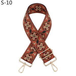 Detail of bohemian orange-red embroidered bag strap with golden metal hooks and buckle