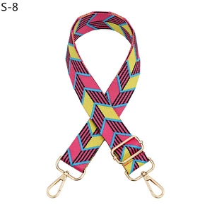 Detail view of high-density polyester bag strap with colorful chevron pattern and gold metal hardware
