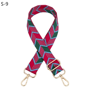 Detail of adjustable woven bag strap with colorful geometric arrow pattern and gold hooks
