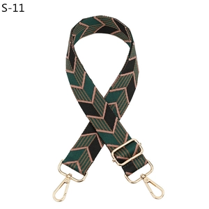 Detail of adjustable bag strap showing contrast leaf pattern and gold metal hardware