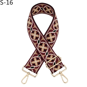 Detail of bohemian burgundy embroidered canvas bag strap with golden metal lobster clasps